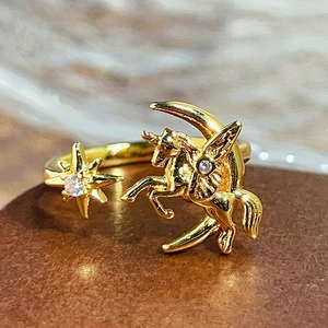 Detalle de anillo vintage dorado con motivos de unicornio luna y estrella con circonitas