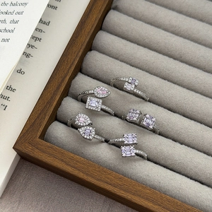 Set mit fünf Silberringen mit rosa und klaren Zirkonen auf grauem Samt präsentiert