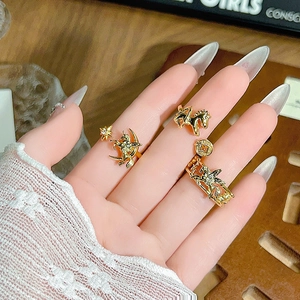 Primer plano de anillos dorados vintage con motivos celestiales y diseños de caballos