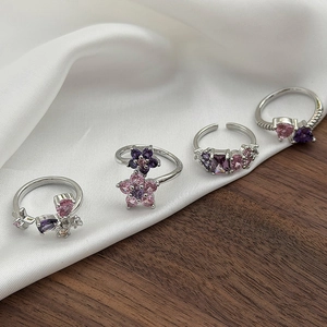 Detail der Silberringe mit lila und rosa Zirkonen und Blumen- sowie Schmetterlingsmotiven