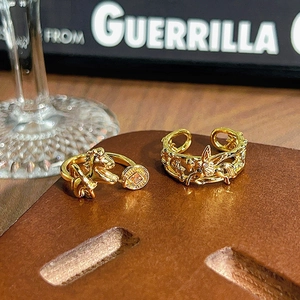 Primer plano de anillos dorados vintage con diseño de caballo y alas sobre cuero