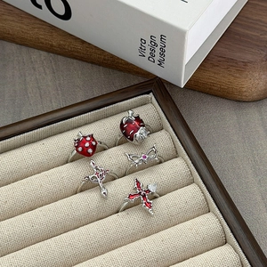 Set van 5 Y2K-stijl ringen met rode emaille aardbei en kruis op een houten dienblad