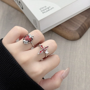 Detail van zilveren ringen met rood emaille aardbei en sterkruis met zirkonia steen