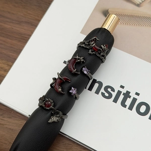 Close-up of gothic gunmetal rings set with red moon, butterfly, and ruby stones