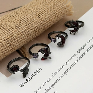 Detailed view of black gothic rings with moon, butterfly and colored gemstones