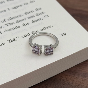 Detailansicht des lila-rosa Zirkon-Blumenrings auf einer offenen Buchseite