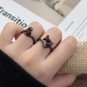 Gothic gunmetal snake rings with red gemstones and detailed scale textures in a close-up