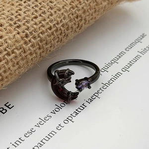 Detail of gothic black open ring with purple gemstone and red moon element