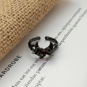 Macro detail of gothic thorn ring with red crescent moon inlay on black metal
