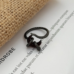 Detailed close-up of dark gothic snake ring with scales winding around red crescent moon