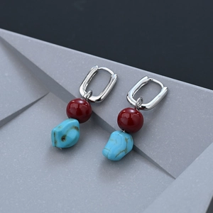 Ethnic earrings featuring red agate beads and irregular turquoise charms on silver hoops