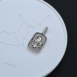 Vintage fleur-de-lis hanger met zirkonia pavé op een hemelse stenen achtergrond