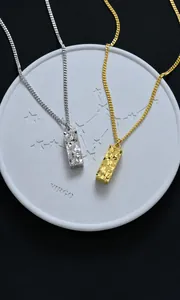 Macro detail of geometric pendant with hammered texture, 17x6mm size and 46cm chain length