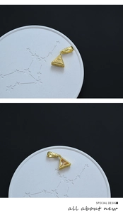 Détail macro du pendentif Œil de la Providence doré avec zircon blanc sur marbre noir