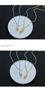 Detailed view of gold and silver rectangular seal pendants with hammered metal texture