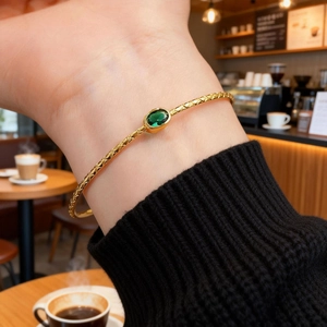 Elegant gold open bangle with emerald green zircon and textured lattice pattern for women