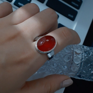 Anillo vintage con ágata roja ovalada y banda plateada lucido en la mano con estilo