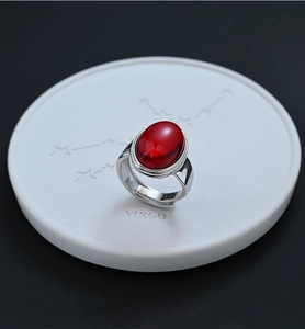 Vista macro de una ágata roja ovalada en un ajuste de anillo abierto de plata