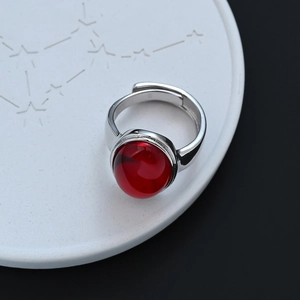 Elegante anillo de plata vintage con piedra preciosa roja ovalada en bandeja cerámica