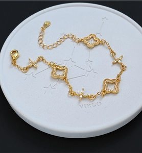 Detailed macro view of S925 sterling silver gold bracelet with clover and flower charms