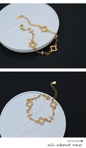 Detailed close-up of a gold clover bracelet with sparkling zircons on a white display plate
