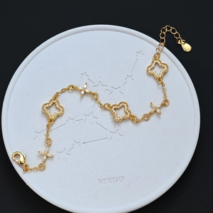 Elegant gold four leaf clover bracelet with white zircons on a Virgo stone tray