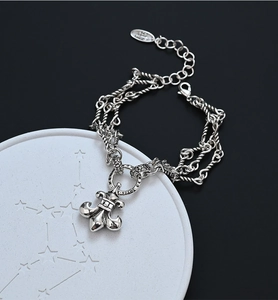 Macro shot of vintage S925 silver braided chain bracelet featuring a Fleur-de-lis charm