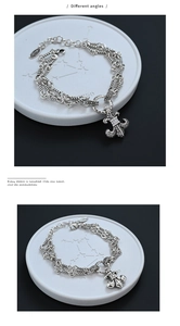 Detailed macro view of vintage silver multi-layer chain bracelet with fleur-de-lis pendant