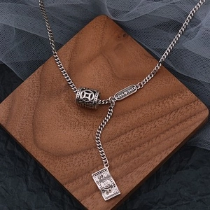 Close-up of vintage silver Y-necklace with lucky beads and dollar bill pendant details