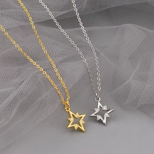 Macro shot of gold and silver octagonal star pendants with inlaid cubic zirconia details