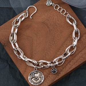 Macro shot of S925 silver bracelet featuring lunar disk pendant and lucky star engraving