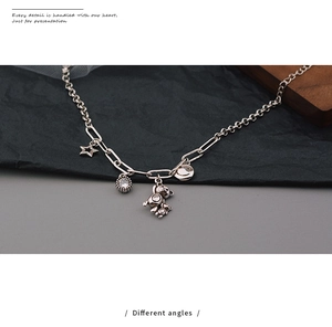 Dettaglio della catena d'argento con ciondoli stella, orsetto, smile e zircone lucido