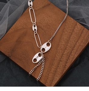 Detail view of silver tassel necklace with pig nose links and paperclip chain style