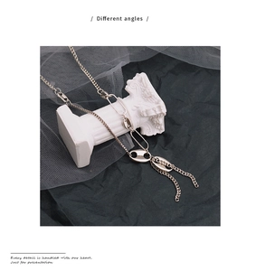 Detailed close-up of mixed silver metal chains and links on a white column