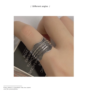 Macro detail of retro hammered silver ring with irregular wave edges and textured finish