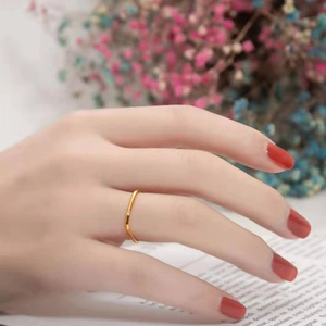 Nahaufnahme eines minimalistischen Goldrings mit kleinem Diamanten am Finger eines Models