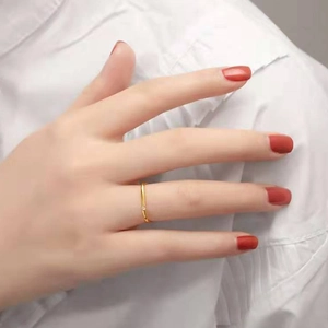 Detailaufnahme eines minimalistischen Goldrings mit kleinem Kristall am Zeigefinger