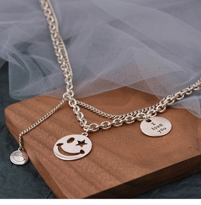 Detail shot of a double-layer silver smile face necklace with engraved I love you pendant