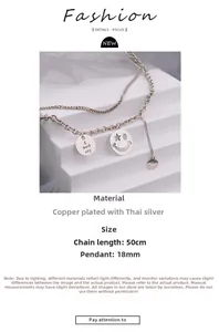 Close-up of double layer silver necklace with star-eyed smiley face and engraved pendant