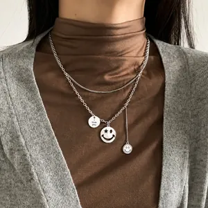 Close-up of double-layer silver chain necklace with smiley face and star pendants
