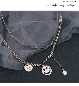 Close-up of double-layer gold chain necklace with smile face and star pendants