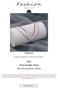 Detail of double-layer vintage silver necklace with LOVE you MORE engraved round pendant