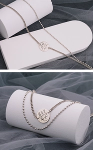 Detailed close-up of double layer silver chain necklace with engraved heart pendant