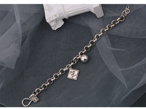 Detailansicht eines Vintage-Silberarmbandes mit Kugel und gravierten Anhängern