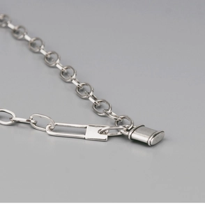 Vue détaillée d'une chaîne trombone argentée avec un pendentif cadenas poli brillant