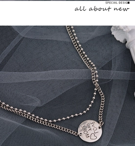 Detail of silver double-layer necklace with More Love engraved round pendant