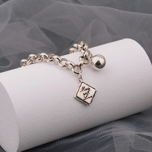 Silbernes Armband mit Perle und graviertem Anhänger auf weißem Sockel im Vintage-Stil