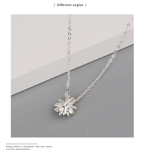 Detailed close-up of a silver daisy pendant necklace with delicate multi-petal floral design