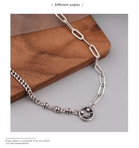 Detail of mixed-link chain necklace with vintage smiley face pendant on a wooden block