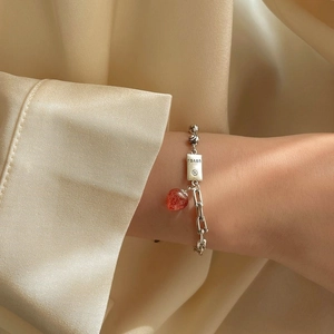 Detailed shot of vintage strawberry crystal bracelet with silver chain on silk background